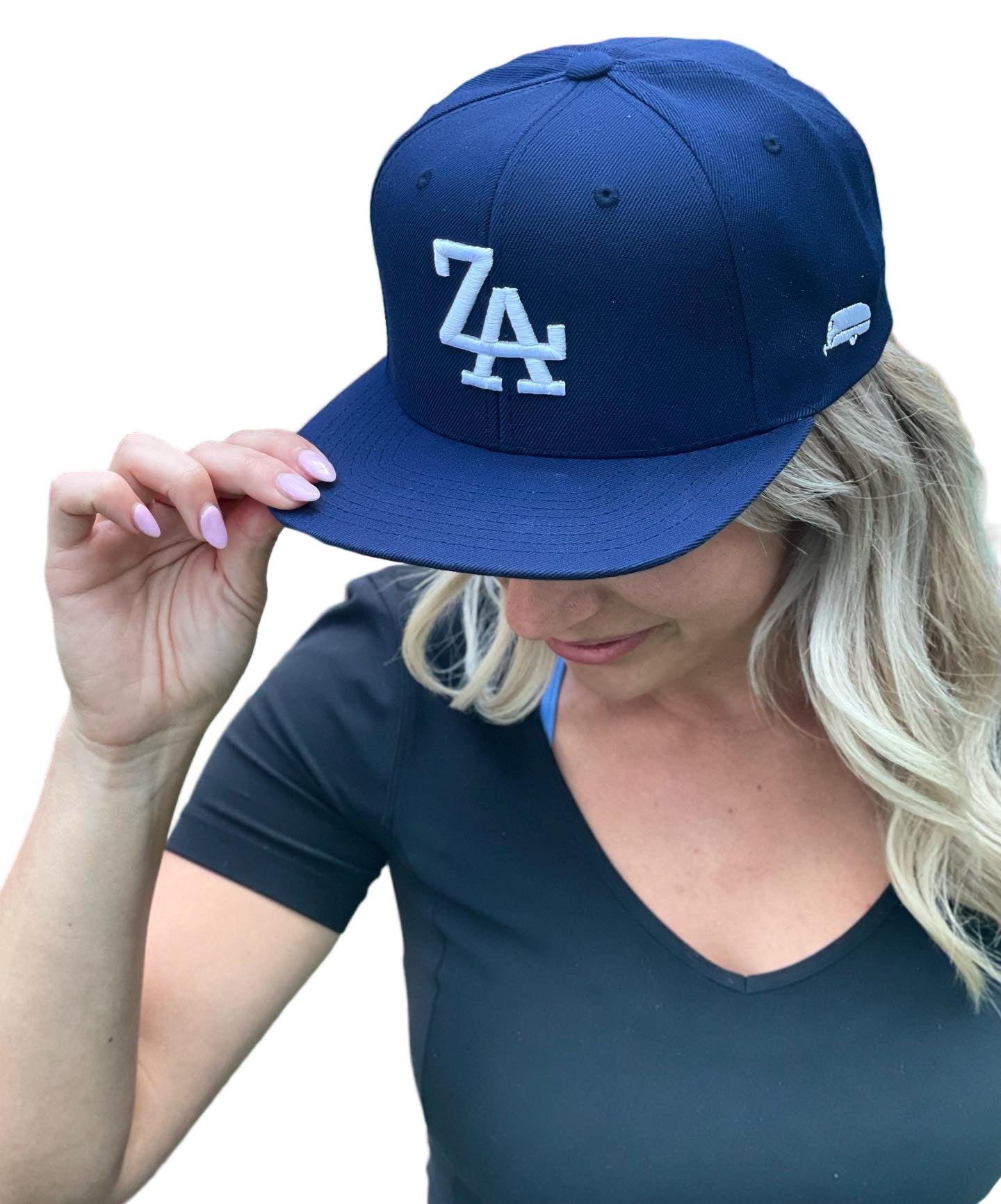 Person wearing a navy cap with a logo in an outdoor setting