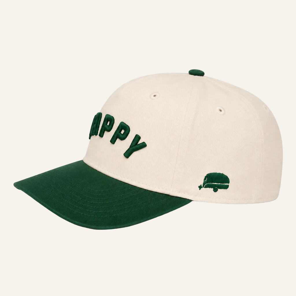 An off-white baseball cap with a dark green curved brim, featuring the word 'HAPPY' embroidered in green on the front and a small green truck graphic on the side.