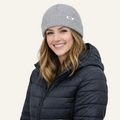 Woman wearing a gray beanie and black puffer jacket on a white background