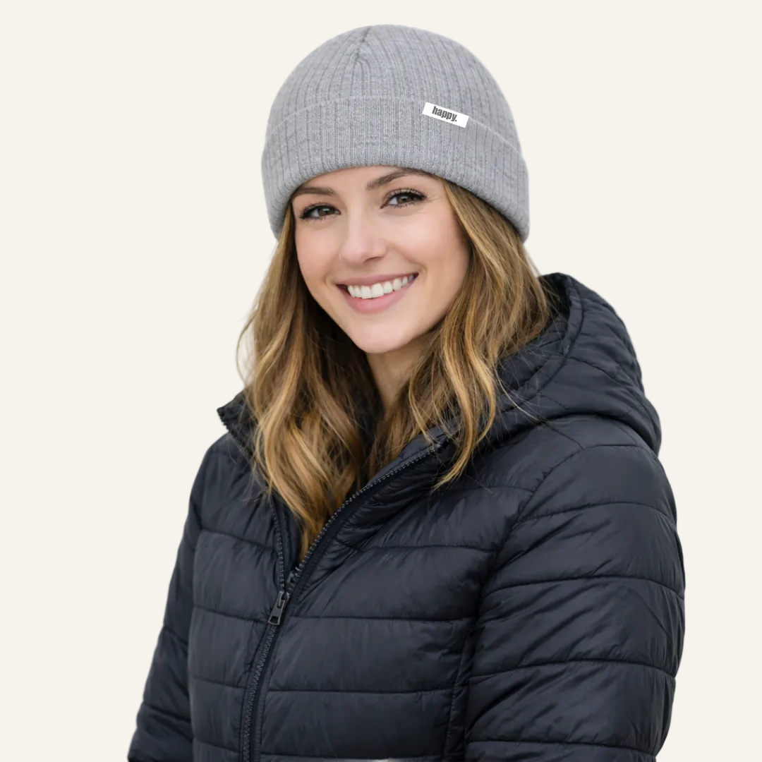 Woman wearing a gray beanie and black puffer jacket on a white background