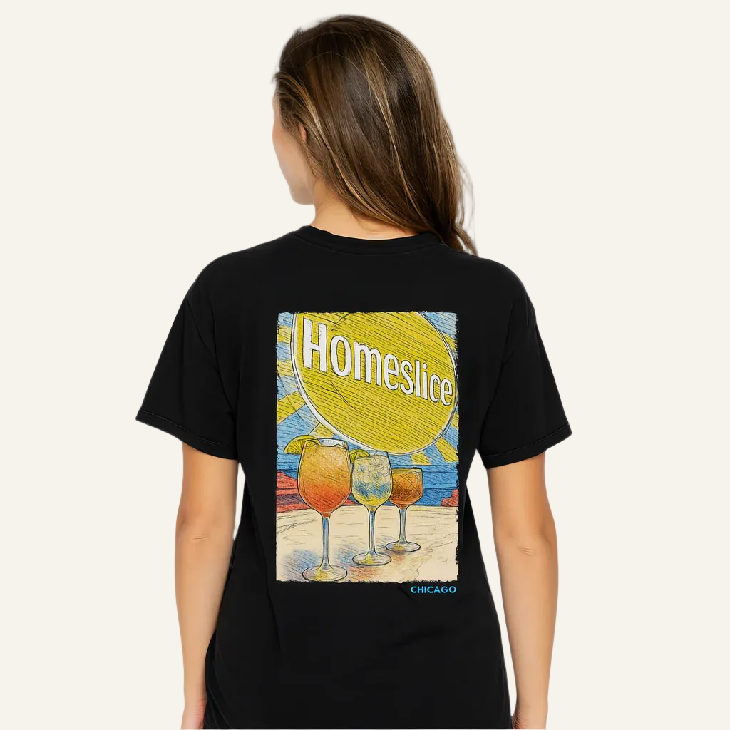 Person wearing a black t-shirt with a colorful graphic design on the back, featuring the word 'Homeslice' and images of drinks.