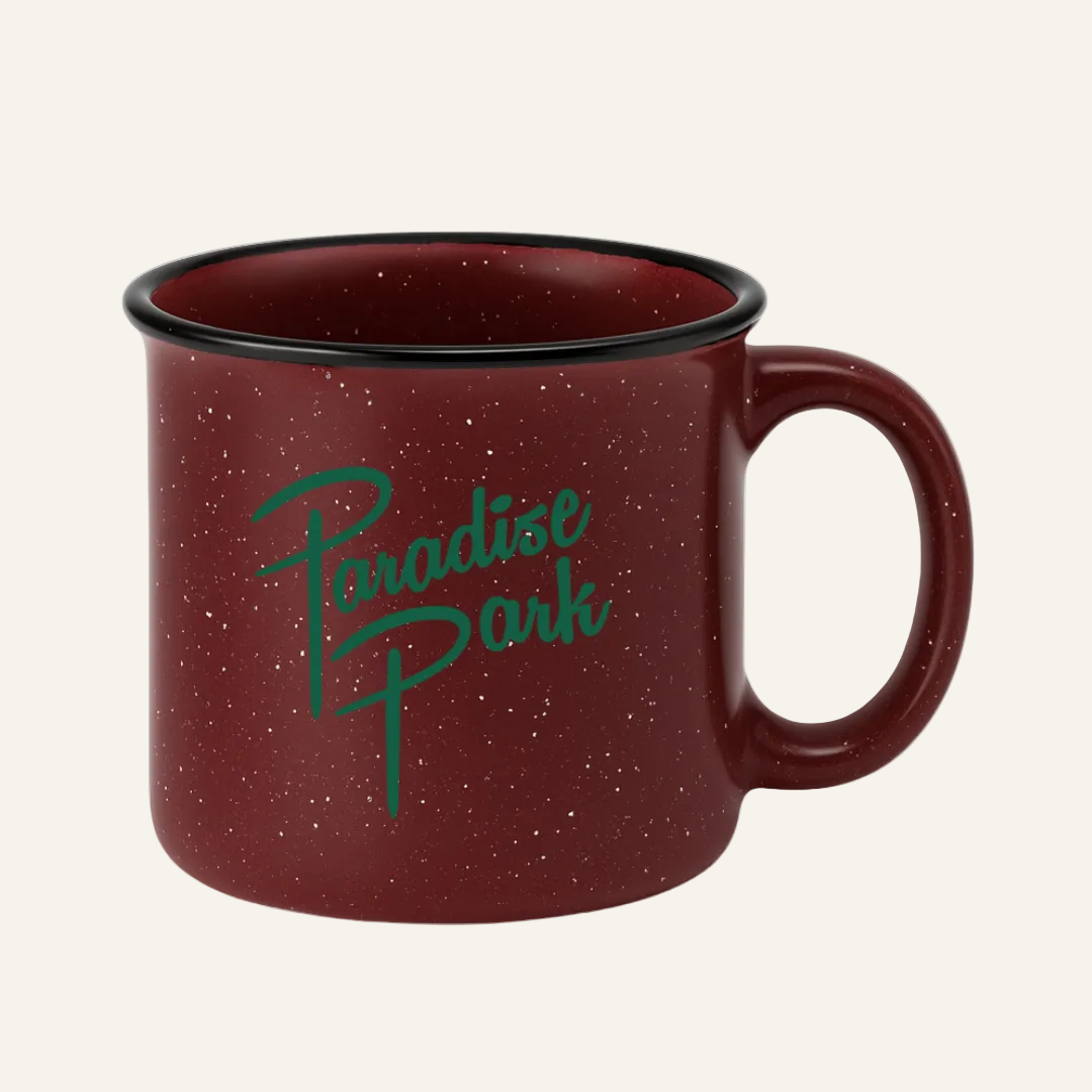 Red speckled mug with 'Paradise Park' text on a white background