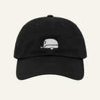 A black dad hat baseball cap featuring a small white embroidered retro camper graphic on the front, set against a plain white background.