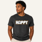 A man wearing a dark heather gray t-shirt with a white and gold 'HAPPY' graphic on the chest, paired with light beige pants, set against a plain white background.