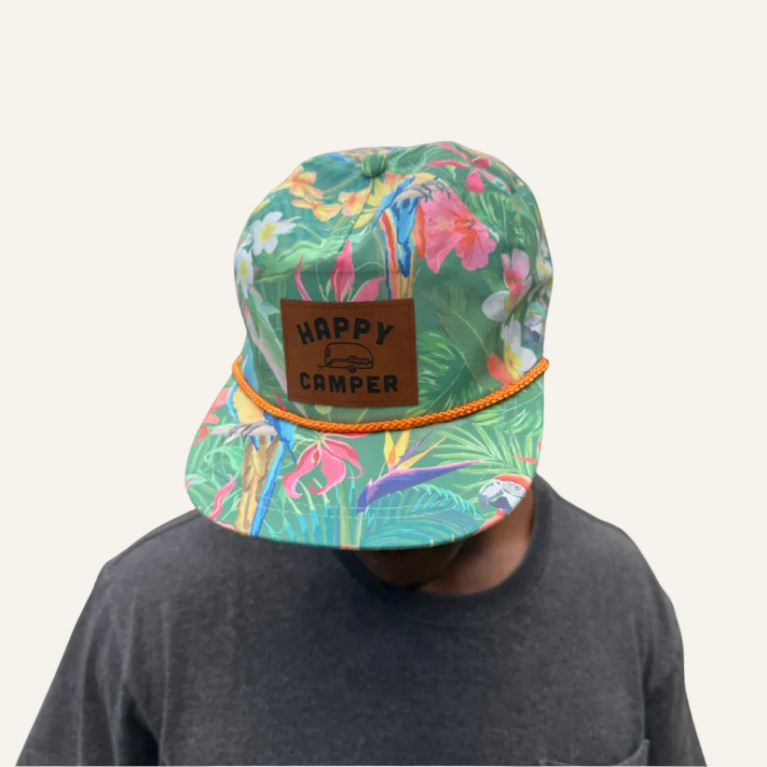 Colorful cap with tropical pattern and 'Happy Camper' label on a white background