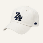 An off-white baseball cap featuring a navy blue embroidered 'ZA' logo on the front and a small navy blue side logo, set against a plain white background.